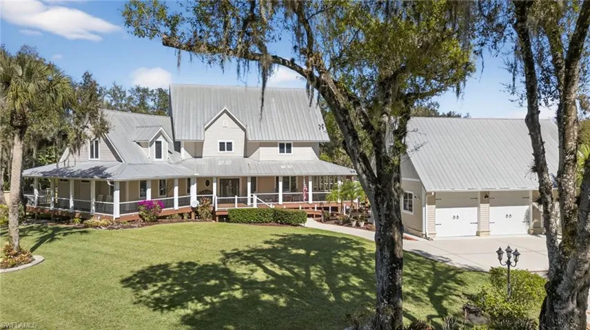 View of front of house featuring a large porch, a front yard, a metal roof, and concrete driveway