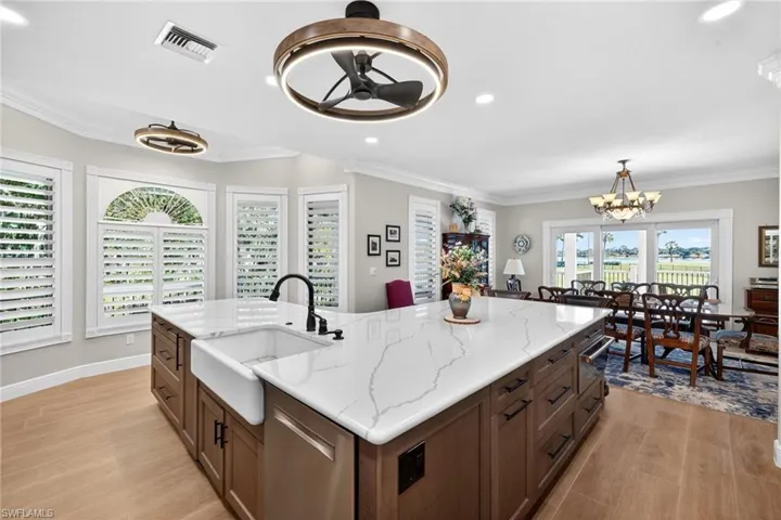 Kitchen featuring stainless steel dishwasher, Quartz counters, suspended lighting, a kitchen island with sink, and a ceiling fan