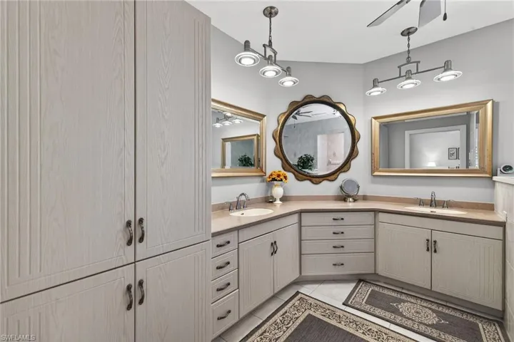 2nd level Primary bath with double vanity, light tile patterned floors, and ceiling fan