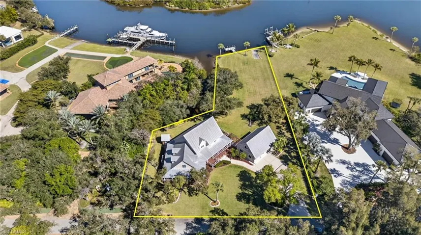 Aerial view of property and surrounding area featuring a large body of water and property boundaries highlighted
