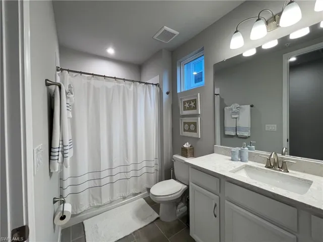 Bathroom featuring vanity and dark tile patterned floors