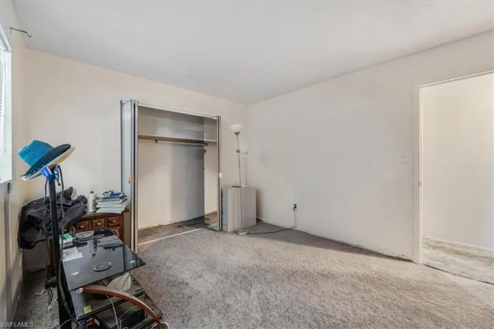 Carpeted bedroom with a closet and a desk