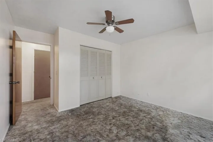 Unfurnished bedroom featuring carpet, a closet, and ceiling fan