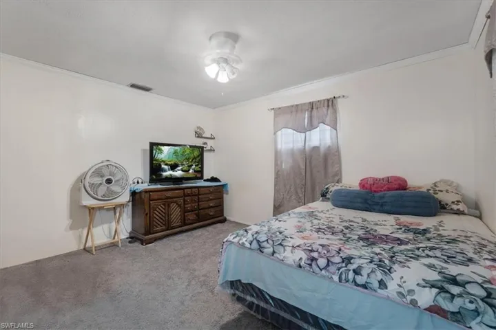 Bedroom featuring ornamental molding and carpet flooring