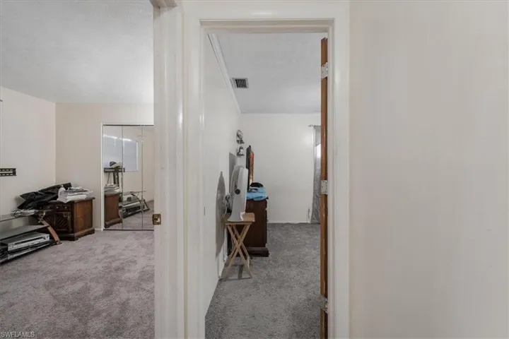 Hall featuring light colored carpet