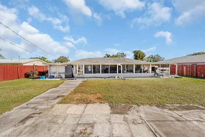 Back of property featuring a fenced backyard, a sunroom, and a patio