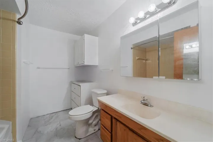 Full bathroom featuring vanity and a textured ceiling