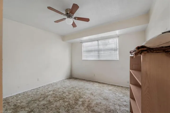 Spare room featuring ceiling fan and carpet