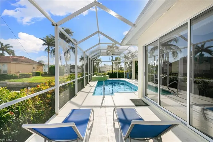 View of pool with screen enclosure and patio area