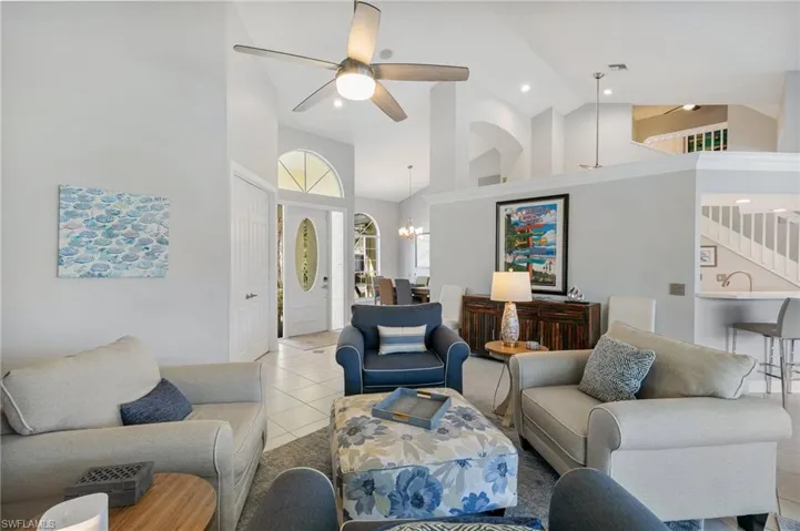 Living room featuring high vaulted ceiling, and ceiling fan