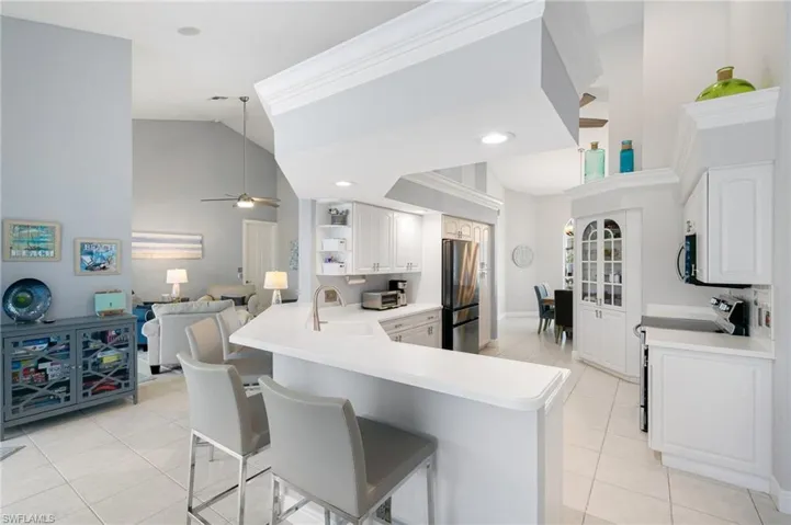 Kitchen with a breakfast bar, ceiling fan, kitchen peninsula, and stainless steel appliances