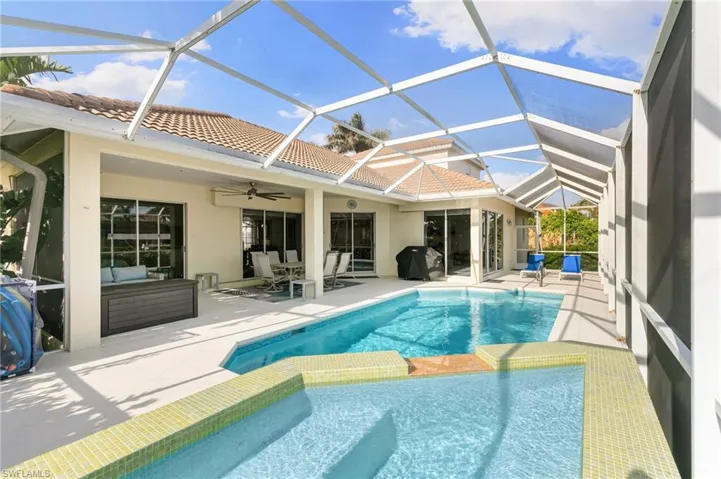 View of pool with a patio area, ceiling fan, and screen enclosure