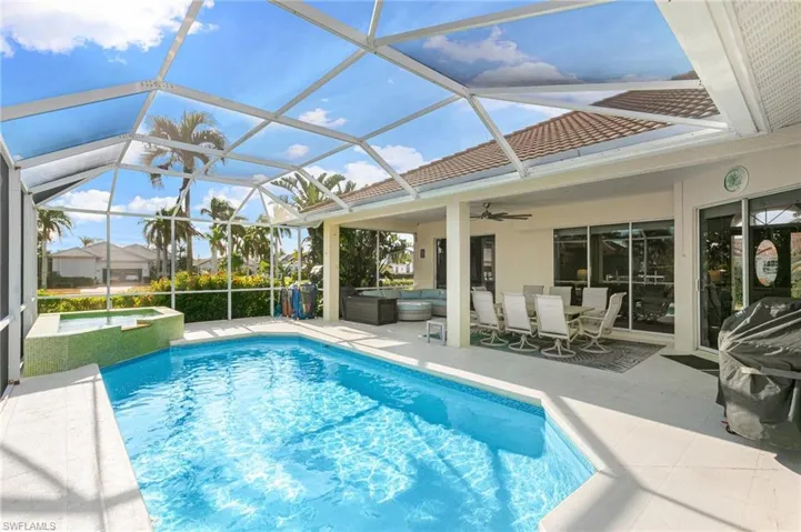 Heated pool with covered lanai, ceiling fan, lounging and dining area