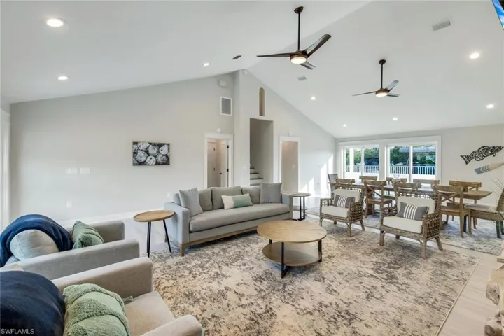 Living room featuring a high ceiling, recessed lighting, and a ceiling fan