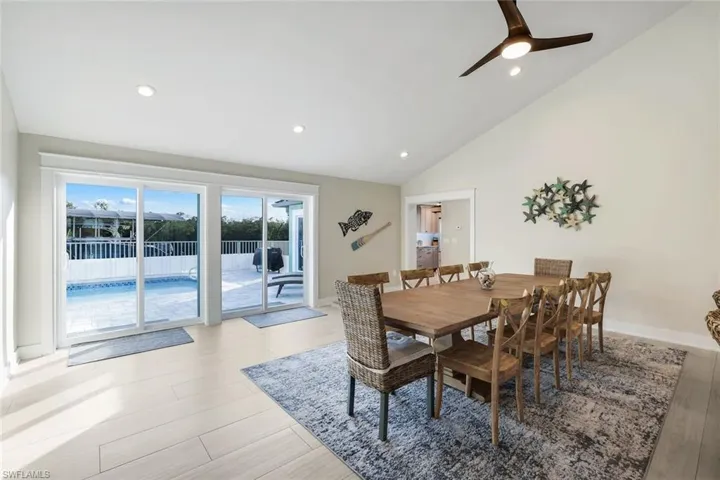 Dining space with light wood-type flooring, a ceiling fan, lofted ceiling, and recessed lighting
