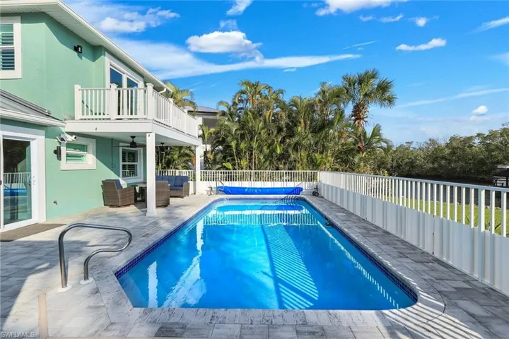 View of pool featuring patio surround, an outdoor hangout area, and a fenced backyard
