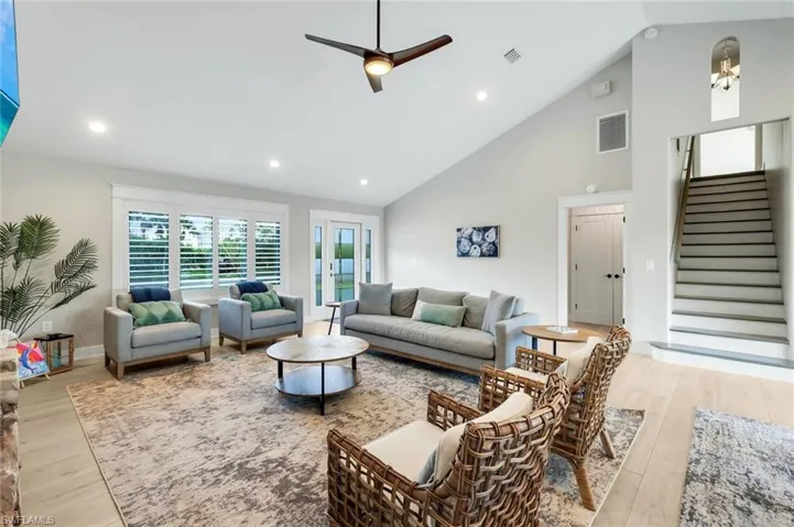 Living room featuring a ceiling fan, recessed lighting, light wood-style floors, and vaulted ceiling