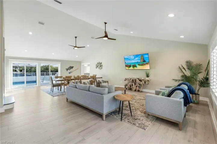 Living area featuring light wood-style floors, recessed lighting, lofted ceiling, and a ceiling fan