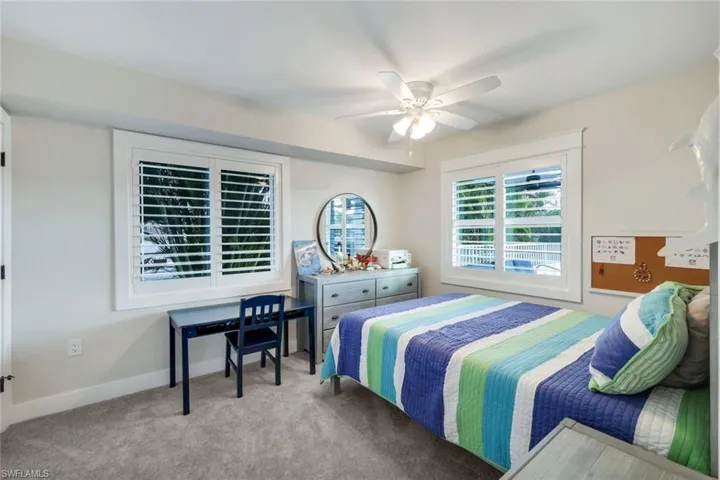 Carpeted bedroom featuring baseboards and a ceiling fan