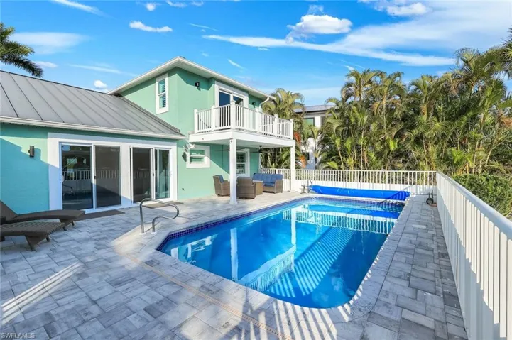 View of pool featuring outdoor seating, patio surround, and a balcony