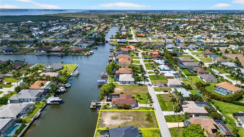 Aerial perspective of suburban area featuring a nearby body of water and property parcel outlined