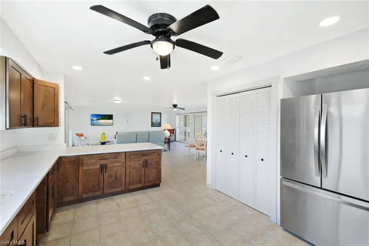 Kitchen with freestanding refrigerator, open floor plan, a peninsula, recessed lighting, and a ceiling fan