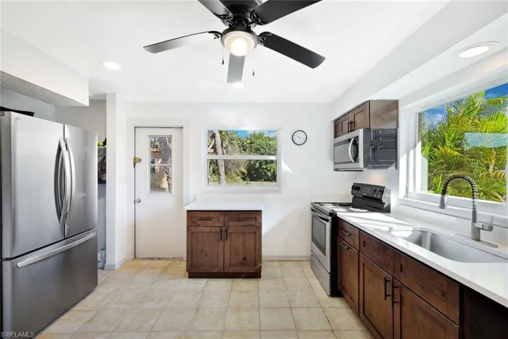 Kitchen featuring appliances with stainless steel finishes, recessed lighting, dark brown cabinetry, a ceiling fan, and light tile patterned floors