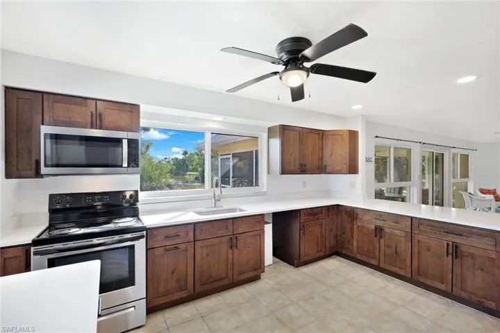 Kitchen with appliances with stainless steel finishes, a ceiling fan, recessed lighting, and a peninsula