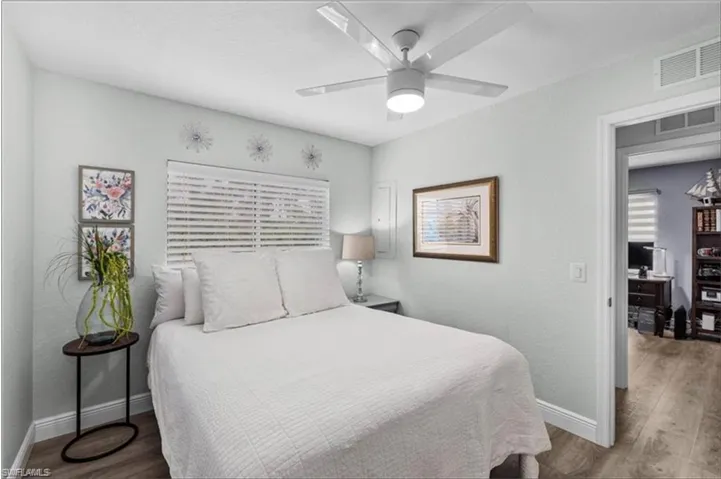 Bedroom featuring baseboards, wood finished floors, and a ceiling fan