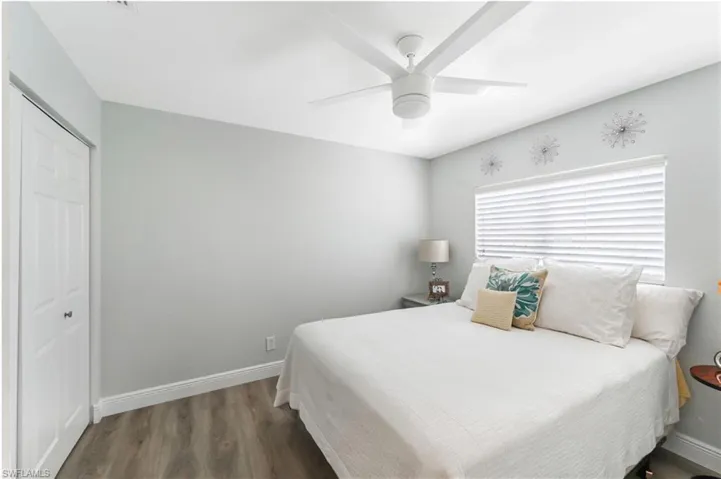 Bedroom with wood finished floors, baseboards, a closet, and ceiling fan