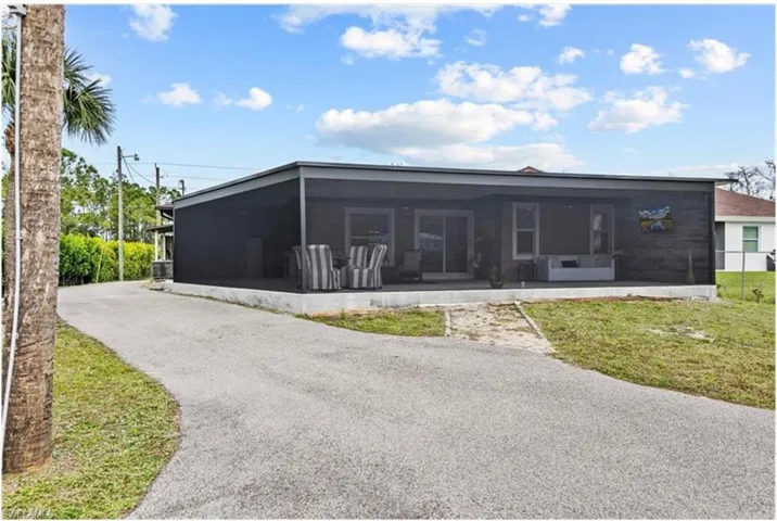 Back of house with a sunroom and a yard