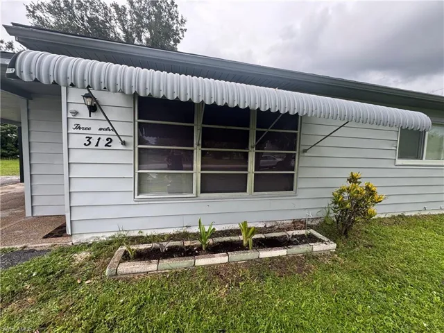 View of side of property with a lawn