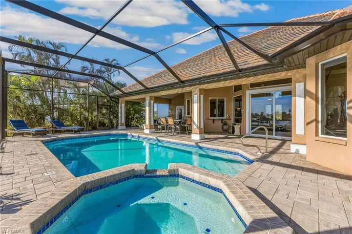 View of swimming pool with a sunroom, a patio, a pool with connected hot tub, a lanai, and outdoor dining area
