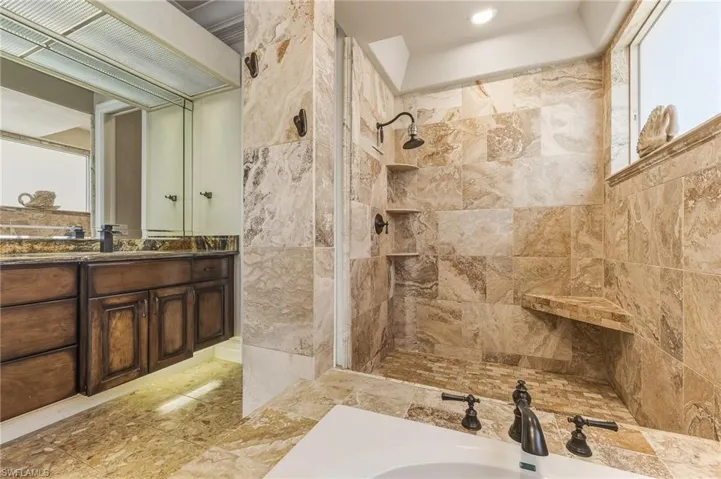 Bathroom featuring vanity and a tile shower