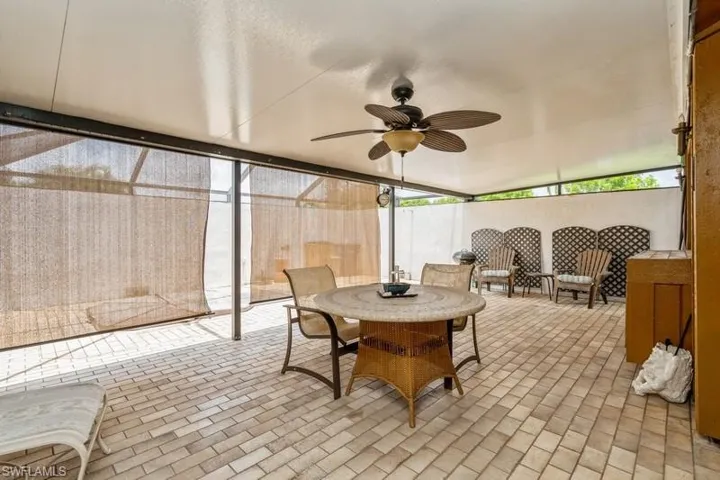Sunroom / solarium with a ceiling fan and outdoor dining area