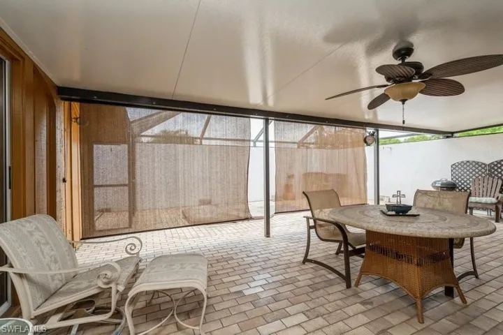 Sunroom / solarium with a ceiling fan and outdoor dining area