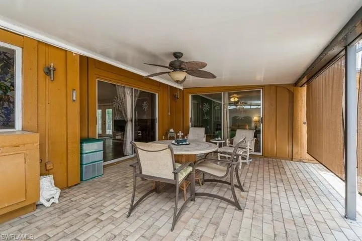 Sunroom with a ceiling fan and outdoor dining space