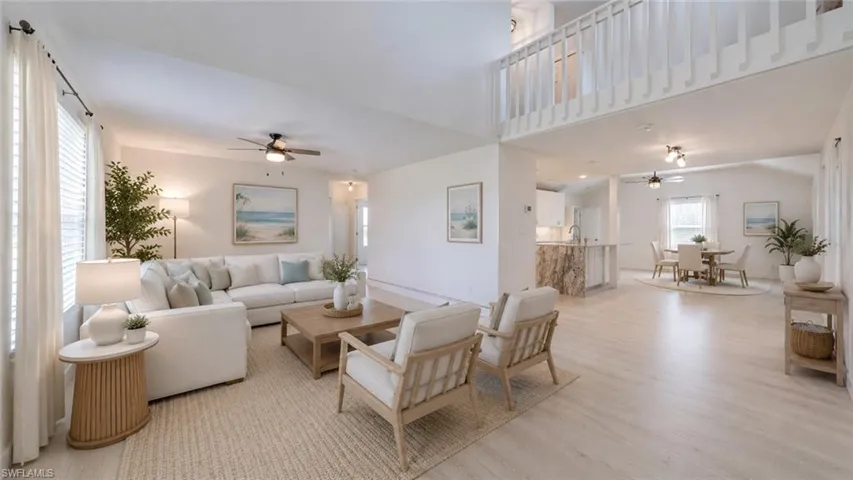 Virtual - Spacious open-concept interior featuring light wood-finish flooring and vaulted ceilings