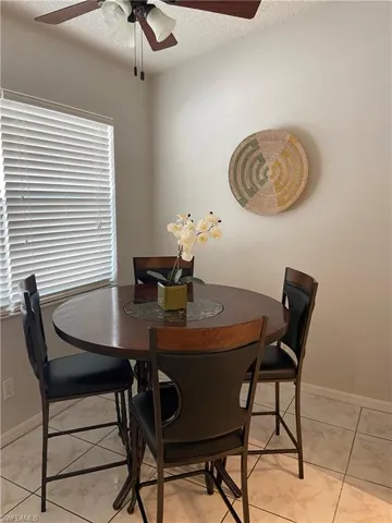 Dining room with baseboards, a textured ceiling, and a ceiling fan