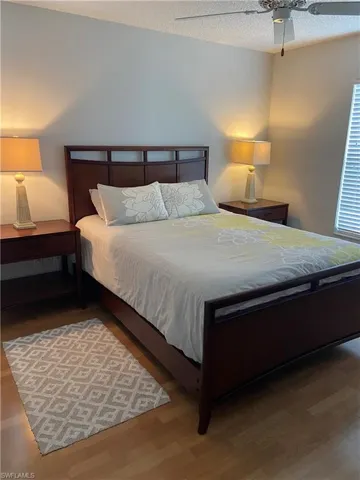 Bedroom featuring a textured ceiling, wood finished floors, and ceiling fan