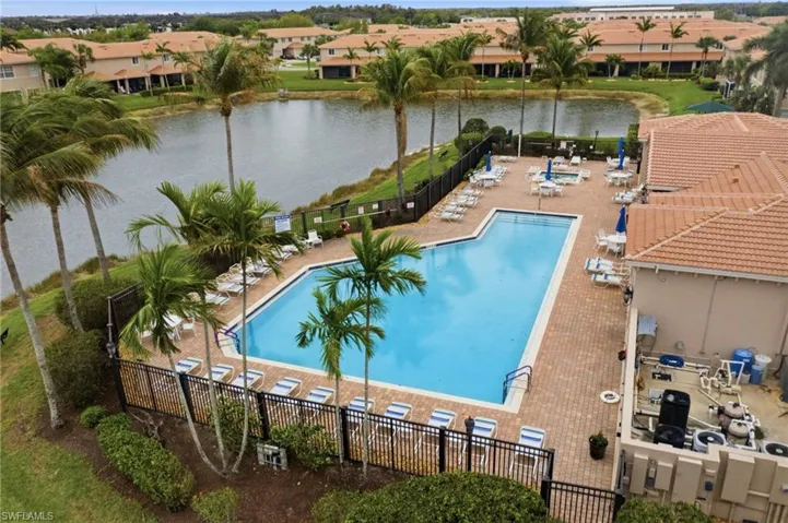 Community pool with a water view and a patio area
