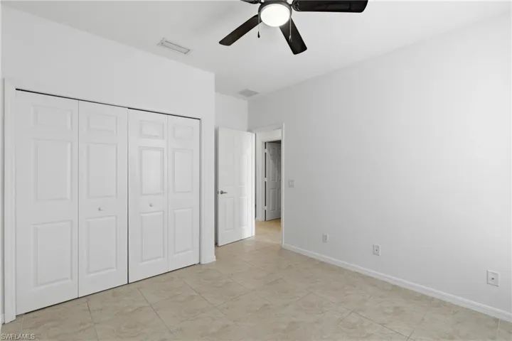 Unfurnished bedroom featuring ceiling fan and a closet