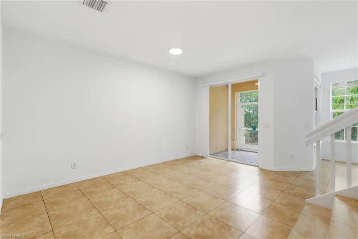 Unfurnished room featuring stairs and light tile patterned floors