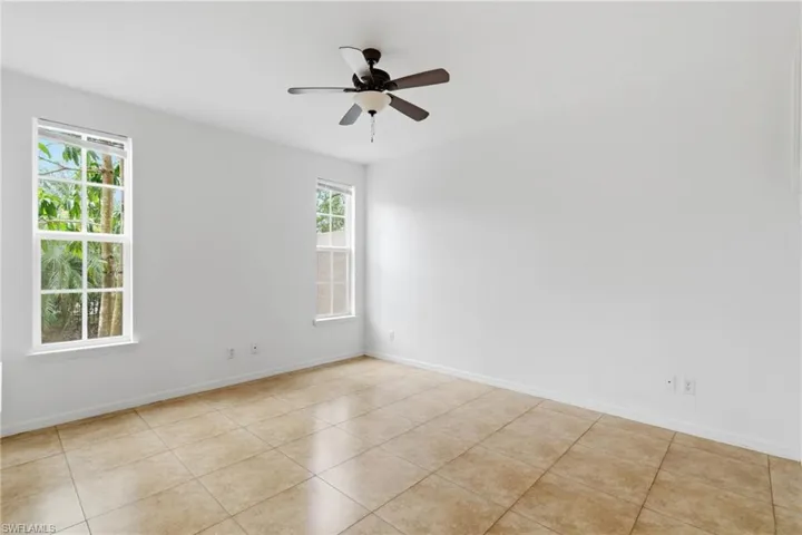 Spare room featuring ceiling fan and light tile patterned flooring