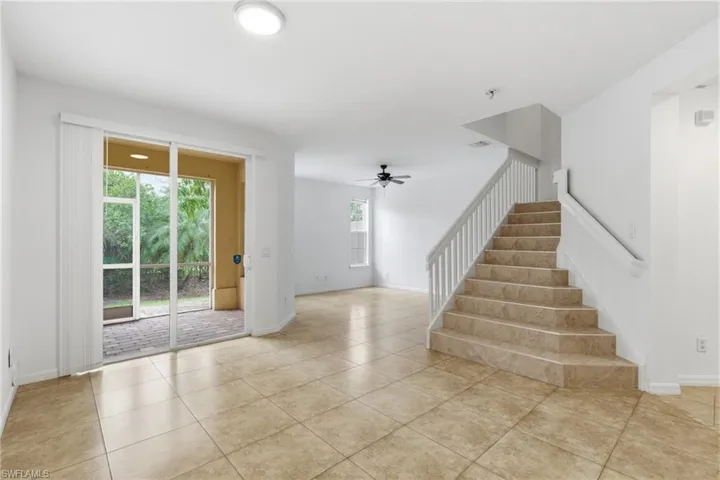 Stairs featuring tile patterned floors and ceiling fan