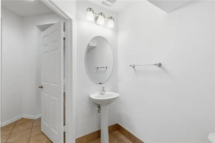Bathroom with light tile patterned floors and baseboards