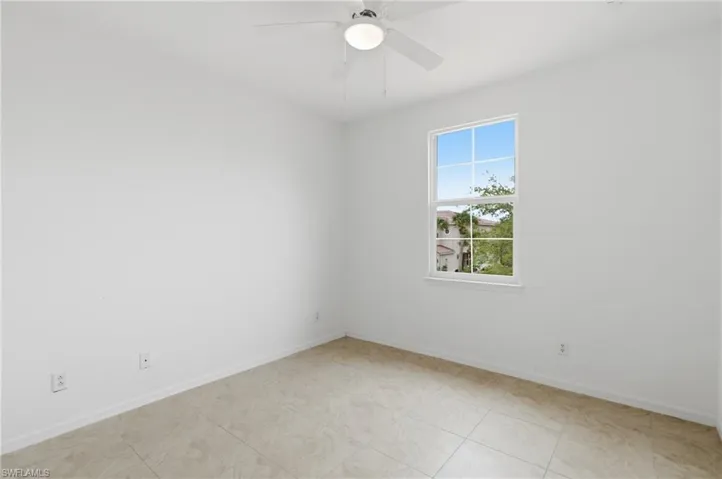 Spare room featuring ceiling fan and baseboards