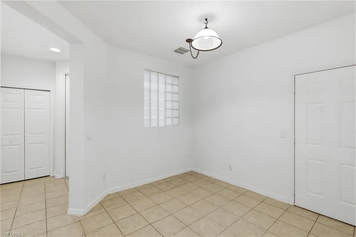 Unfurnished dining area with light tile patterned floors and recessed lighting
