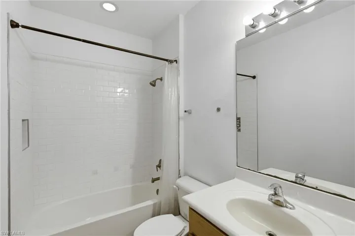 Full bath with vanity, shower / bath combo with shower curtain, and recessed lighting