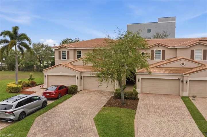 Mediterranean / spanish home with stucco siding, a tile roof, driveway, and a garage